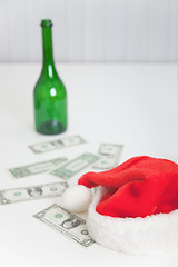 Image showing On white table bottle, christmas hat and money