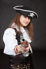 Image showing Young woman in suit of the pirate aims a pistol