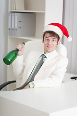 Image showing Businessman begins Christmas celebrating at office on workplace