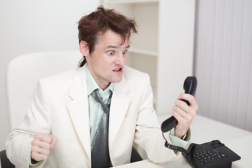 Image showing Person emotionally communicates with phone at office