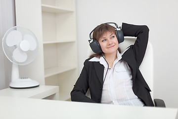 Image showing Woman listens to music in ear-phones