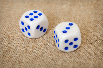Image showing Two playing dices with blue points on brown canvas