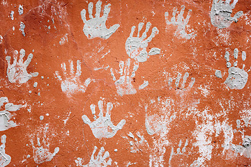Image showing Concrete red wall with prints of hands