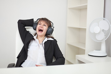 Image showing Girl funny sings sitting in an armchair at office