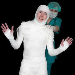 Image showing Funny sick in bandage and nurse on black background
