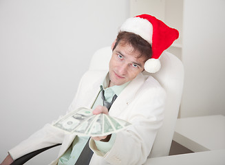 Image showing Businessman in white suit and Christmas cap gives us money