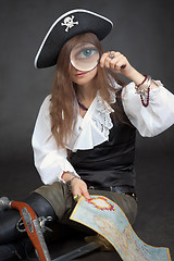 Image showing Woman in clothes of pirate with sea map and magnifier glass
