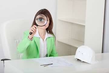 Image showing Amusing girl looks at us through big magnifier