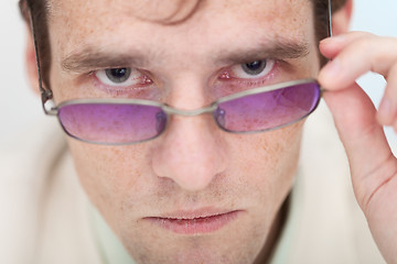 Image showing Man seriously and strictly looks at us over glasses