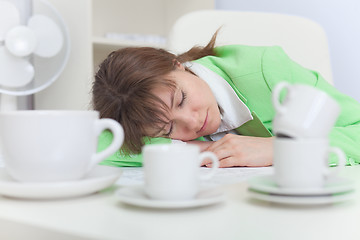 Image showing Beautiful woman sleeps on workplace with coffee cups