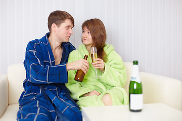 Image showing Young pair at home on divan with beer and wine