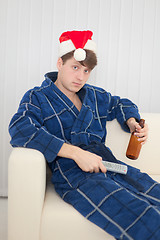 Image showing Man in Christmas cap with remote control and beer