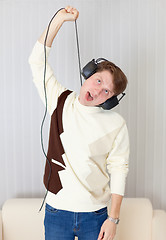 Image showing Young man smothers itself wire from stereo-ear-phones