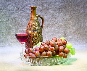 Image showing Still-life with clay bottle, grapes and glass on canvas