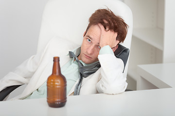 Image showing Young drunken man at office with a beer bottle