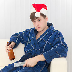 Image showing Man in Christmas cap with remote control and beer