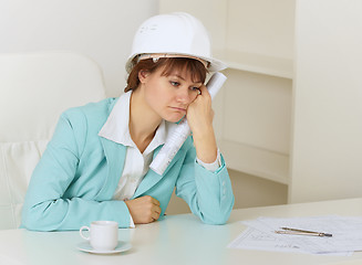 Image showing Woman engineer sits on workplace at office and mourns