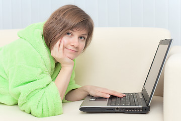 Image showing Portrait of young woman in dressing gown with laptop