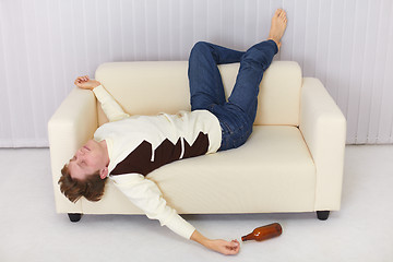 Image showing Drunk person funny sleeps on sofa