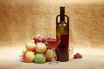 Image showing Still-life - bottle of wine and fruit against a canvas