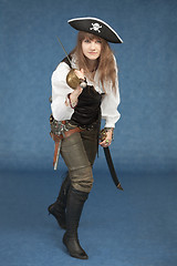 Image showing Woman - sea pirate on blue background with sabre and pistol