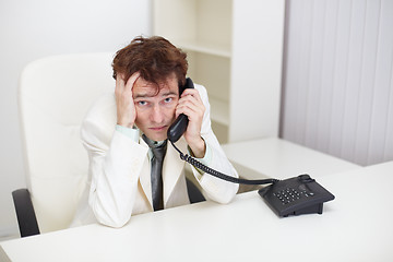 Image showing Tired businessman tensely speaks on phone