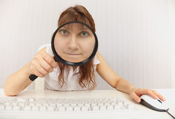 Image showing Amusing girl with computer keyboard and magnifier