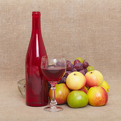 Image showing Still-life - red bottle of wine and fruit against a canvas