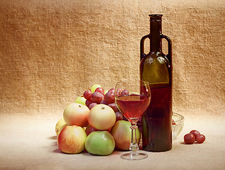 Image showing Wine and fruit against brown sacking