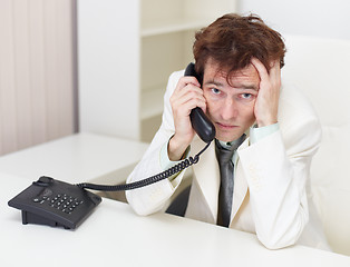 Image showing Person excited communicates by phone sitting at a table