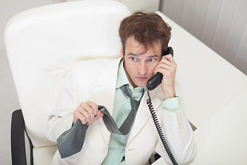 Image showing Businessman in white jacket emotionally talks by phone