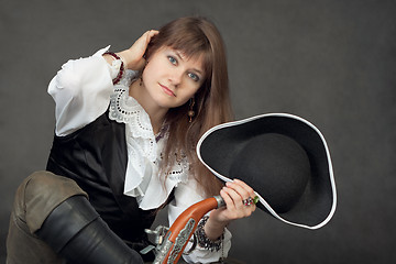 Image showing Young beautiful woman in costume of pirate on black background