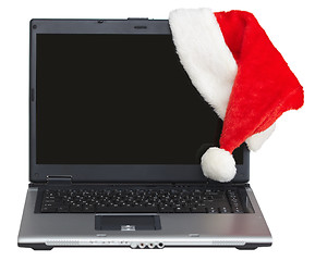 Image showing New Year s laptop with blank screen and santa cap