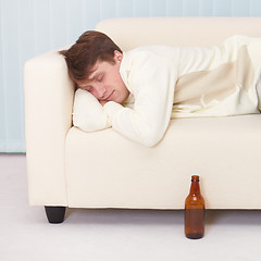 Image showing Person comfortable sleeps on sofa having got drunk beer