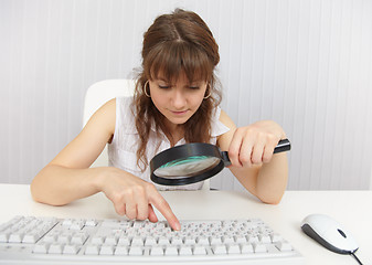 Image showing Girl with poor eyesight works on keyboard by means of magnifier