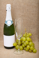 Image showing Still-life from bottle of sparkling wine, empty glass and grapes