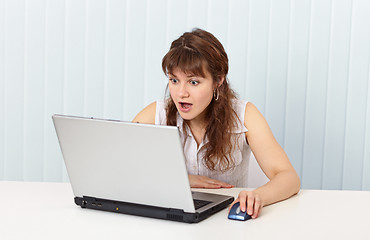 Image showing Indignant woman works in Internet with laptop