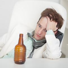 Image showing Person suffers from hangover sitting at a table