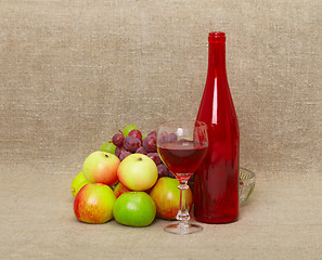 Image showing Still-life - bottle and fruit against a canvas