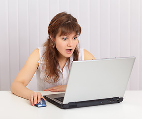 Image showing Young beautiful woman funny emotionally looking in laptop screen