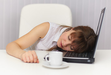 Image showing Young girl sleeps on laptop keyboard