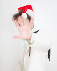 Image showing Person in Christmas cap closes face a hand