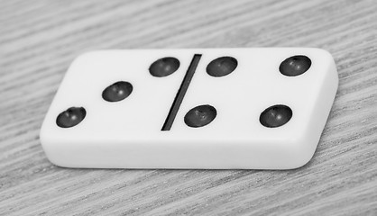 Image showing One dominoes lies on wooden surface close up