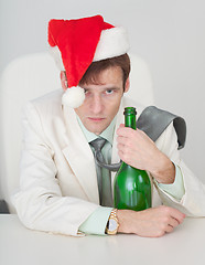 Image showing Guy in Christmas cap with a bottle in hand