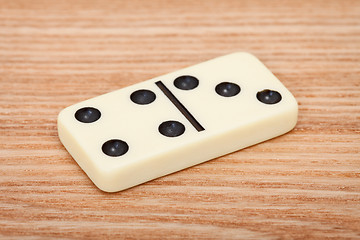 Image showing One tile dominoes on wooden surface close up