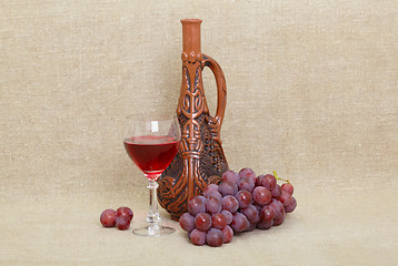 Image showing Composition from clay Georgian bottle, glass and grapes