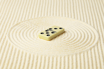Image showing Dominoes on surface of yellow sand - abstract composition