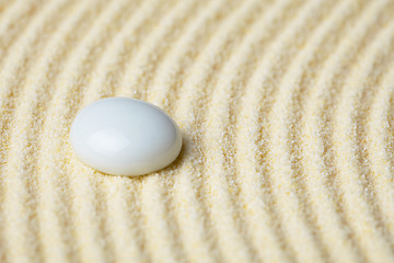 Image showing Ceramic stone on a surface of yellow sand close up