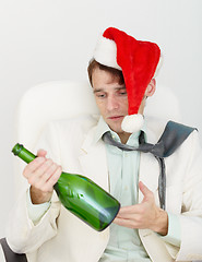 Image showing Young drunkard celebrates new year with wine bottle