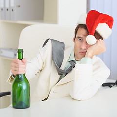 Image showing Young drunkard celebrates Christmas with wine bottle